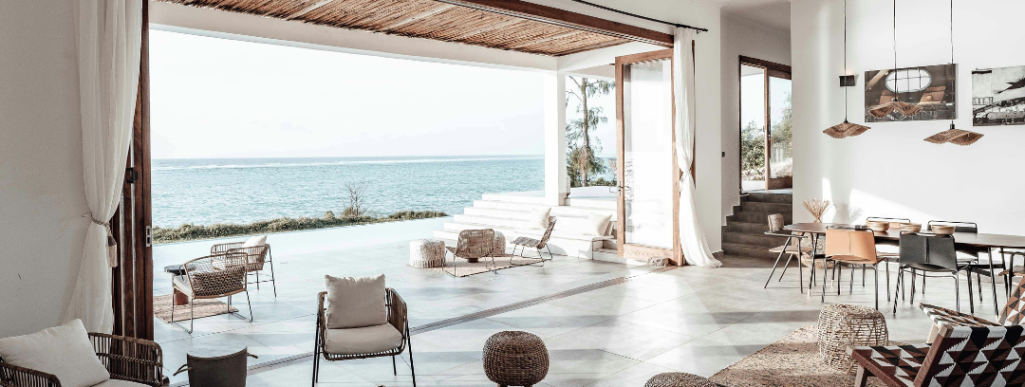 Maison à toit en pente, entourée d'arbres verdoyants.