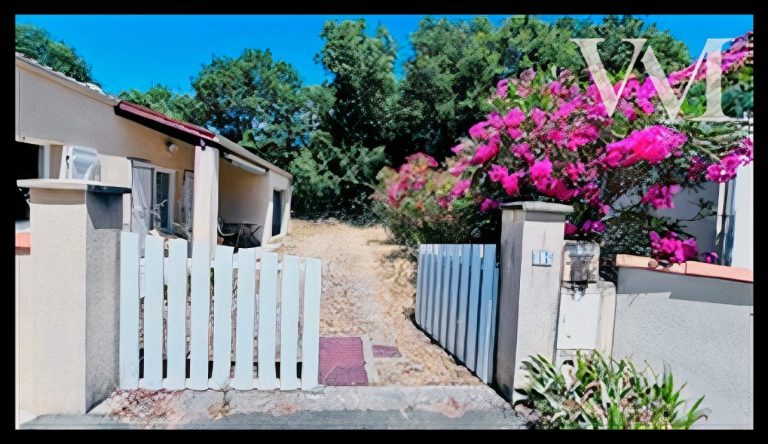 Maison de plain-pied avec un jardin, entourée de fleurs et sous un ciel bleu.