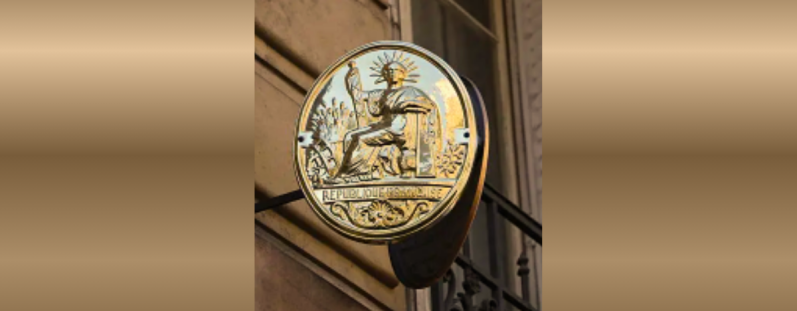 Deux professionnelles du droit au service de votre projet immobilier Plaque ronde dorée représentant le symbole de la justice.