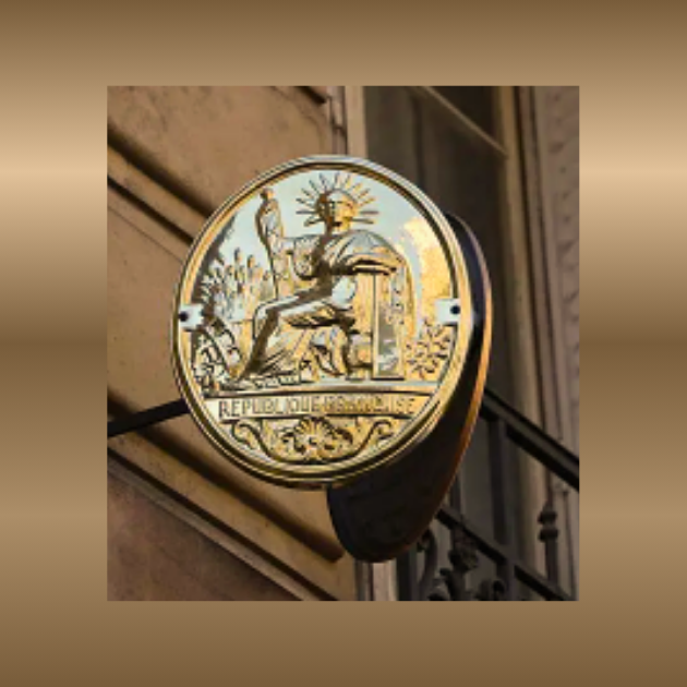 Plaque en métal doré représentant une figure humaine et des motifs floraux.